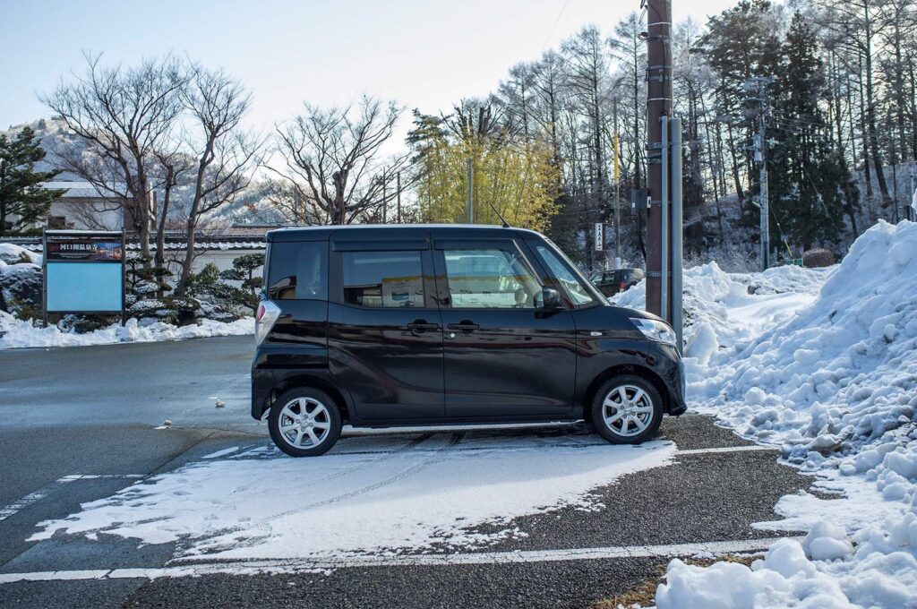Black kei car in snow in Japan