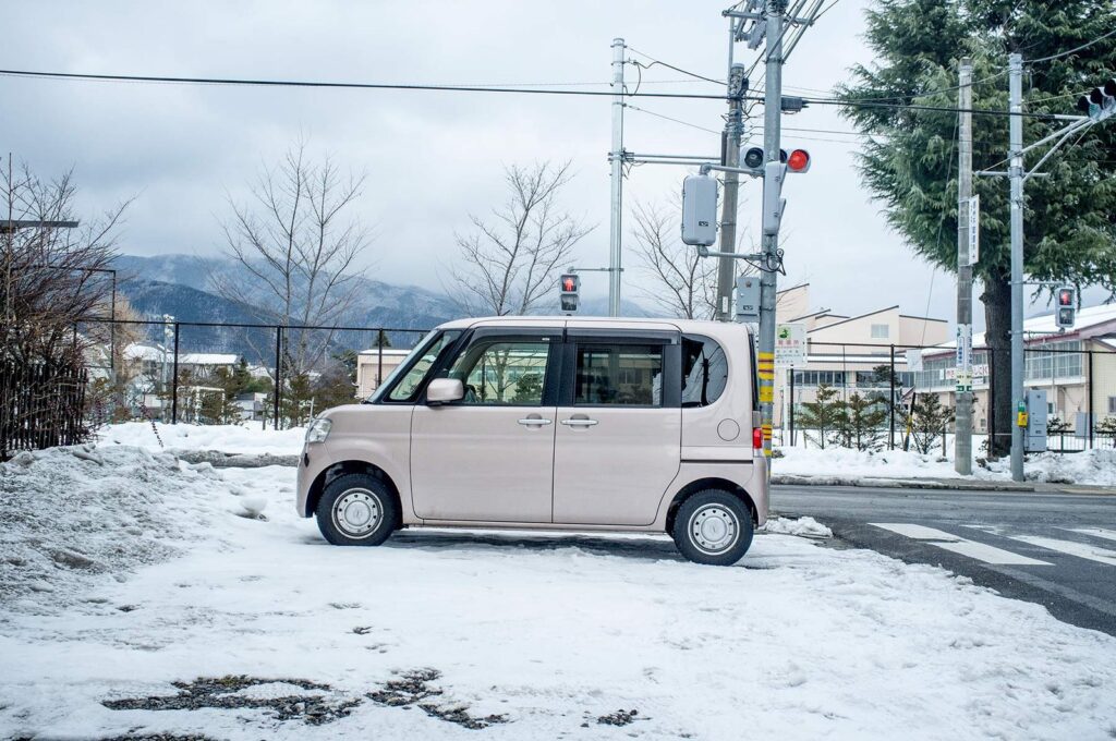 Pink kei car on a snowy street in Japan